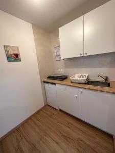 a small kitchen with white cabinets and a sink at Apartment - Pension Marianna in Rust