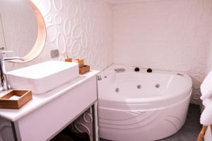 een witte badkamer met een bad en een wastafel bij A un passo dal Castello Maschio ANGIOINO Appartment in Napels