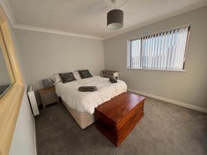 a bedroom with a bed with a wooden table at Cae Teg in Llanfairpwllgwyngyll
