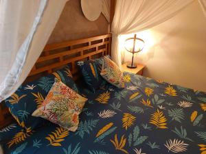 a bed with a blue comforter and pillows on it at Golden Square Villa & Private Pool in Flic-en-Flac