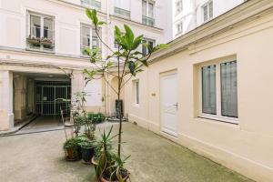 una planta en un patio frente a un edificio en Bright apartment in the 10Arr. - 4 people, en París
