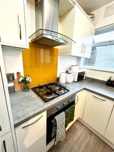 a kitchen with white cabinets and a stove top oven at Powdermill Lodge in Hanworth