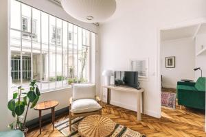 sala de estar con TV y silla en Bright apartment in the 10Arr. - 4 people, en París