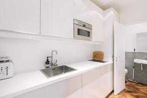 cocina blanca con fregadero y microondas en Bright apartment in the 10Arr. - 4 people, en París