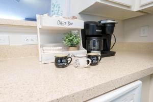 a kitchen counter with three coffee mugs on it at Ballston Getaway King Suite in Arlington