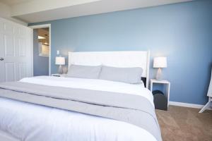 1 cama blanca grande en un dormitorio con paredes azules en Ballston Getaway King Suite, en Arlington