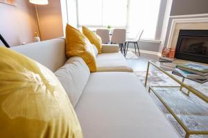 un sofá blanco con almohadas amarillas en la sala de estar. en Ballston Getaway King Suite, en Arlington