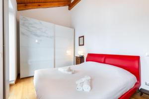 Schlafzimmer mit einem weißen Bett mit einem roten Kopfteil in der Unterkunft Casa Gaia in Guarene