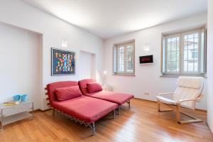 ein Wohnzimmer mit einem roten Sofa und 2 Stühlen in der Unterkunft Casa Gaia in Guarene