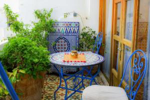 un tavolo blu e sedie sul balcone con tavolo di Dar Lalhambra a Tangeri