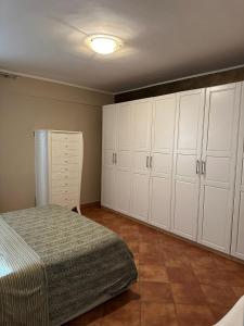 a bedroom with white cabinets and a bed at Casa Begaj in San Giovanni Valdarno