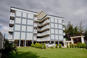 a large building with a car parked in front of it at Olivet Homes in Nanyuki