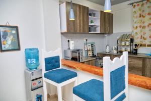 a kitchen with blue and white chairs and a counter at Olivet Homes in Nanyuki