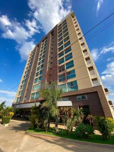 a tall building with palm trees in front of it at Piazza diRoma com acesso ao Acqua Park - Gualberto in Caldas Novas