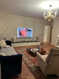 a living room with a couch and a tv on the wall at Casa Begaj in San Giovanni Valdarno