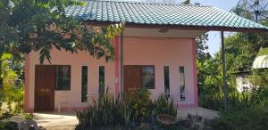 een klein roze huis met een grote deur bij โอคันทรี Ocountry in Khuang Nai