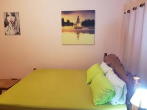 een slaapkamer met een groen bed met 2 kussens bij โอคันทรี Ocountry in Khuang Nai