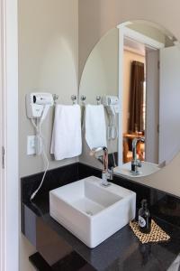 オランブラにあるOnze Tuin vilinha típicaのバスルーム(白い洗面台、鏡付)
