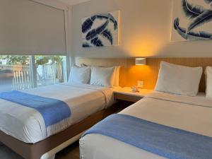 ein Hotelzimmer mit 2 Betten und einem Fenster in der Unterkunft Gilbert's Resort in Key Largo