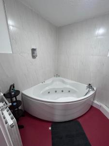 a large white bath tub in a white room at The Office Bar and Restaurant in Dudley