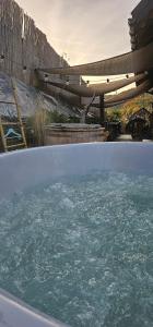 a bath tub filled with water next to a wooden fence at Chata Natura in Muszyna