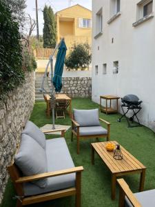 un patio avec des chaises, une table et un grill dans l'établissement Studio avec jardin proche plage Six Fours/Sanary, à Six-Fours-les-Plages