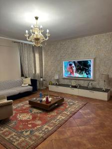 a living room with a couch and a tv on the wall at Casa Begaj in San Giovanni Valdarno