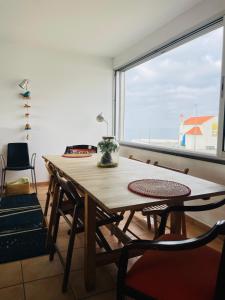 ザンブジェイラ・ド・マールにあるSunset Beach Houseの大きな窓のある客室で、テーブルと椅子が備わります。