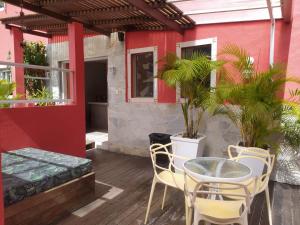 a patio with a table and chairs and a red building at Pousada Villa Encanto in Juquei