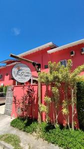 a red building with a sign on the side of it at Pousada Villa Encanto in Juquei