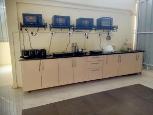 a kitchen with white cabinets and appliances in a room at Wandr Scorpious - Manyata tech park in Bangalore