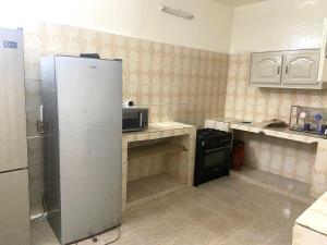 uma cozinha com um frigorífico e um fogão em Villa L6 em Dakar