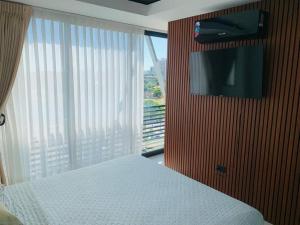 a bedroom with a bed and a tv and a window at Departamento con vista de lujo in Santa Cruz de la Sierra
