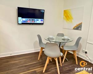 a dining room with a table and chairs and a tv at 1 Bedroom Apartment by Central Serviced Apartments - Close To University of Dundee - Sleeps 2 - Ground Level - Self Check In - Modern and Cosy - Fast WiFi - Heating 24-7 in Dundee