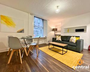 - un salon avec un canapé et une table dans l'établissement 1 Bedroom Apartment by Central Serviced Apartments - Close To University of Dundee - Sleeps 2 - Ground Level - Self Check In - Modern and Cosy - Fast WiFi - Heating 24-7, à Dundee