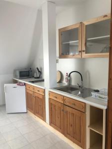 una cucina con armadi in legno, lavandino e frigorifero di Szabó Ház a Hévíz