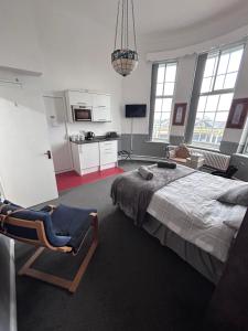 1 dormitorio con 1 cama y 1 silla en The Office Bar and Restaurant, en Dudley