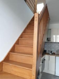 a wooden staircase in a kitchen with a stair case at Charming & practical near Paris in Gentilly