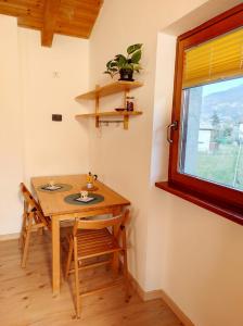 - une table et des chaises dans une chambre avec fenêtre dans l'établissement Residence Salvadori, à Rovereto