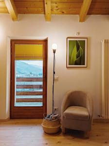 un salon avec une chaise et une lampe dans l'établissement Residence Salvadori, à Rovereto