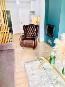 Βίλα Βασιλική في Elassona: غرفة معيشة مع كرسي جلدي وطاولة زجاجية