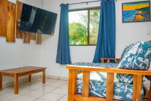 Buena Vista El Zonte في الزونت: غرفة معيشة مع مقعد ونافذة