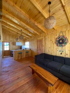 sala de estar con sofá azul y cocina en Cabañas Rumi Loft, en Valdivia