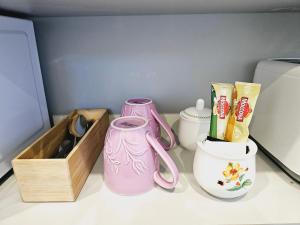 a shelf with two pink vases and a wooden box at Hillcrest Home in Hamilton
