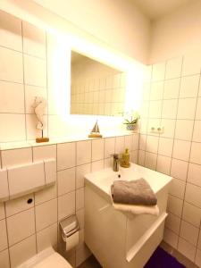 ein Badezimmer mit einem Waschbecken, einem WC und einem Spiegel in der Unterkunft Neuwertige Wohnung in Top Lage incl. Parkplatz in Magdeburg