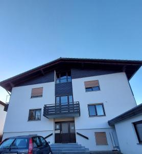 un edificio blanco con un coche aparcado delante de él en Chiemsee /Seeblick/ Netflix, en Seeon-Seebruck