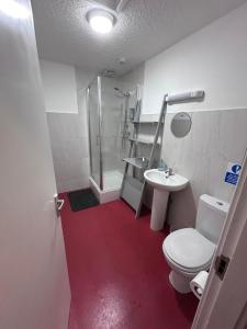 a bathroom with a toilet and a sink and a shower at The Office Bar and Restaurant in Dudley