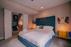um quarto com uma cama grande e uma cabeceira azul em Denver Urban Retreat - 3BR Rooftop w City Views em Denver