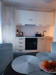 a kitchen with a table with a plate of fruit on it at Trnsko in Zagreb