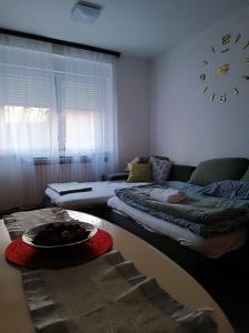 a living room with two beds and a clock on the wall at Trnsko in Zagreb +7 photos
